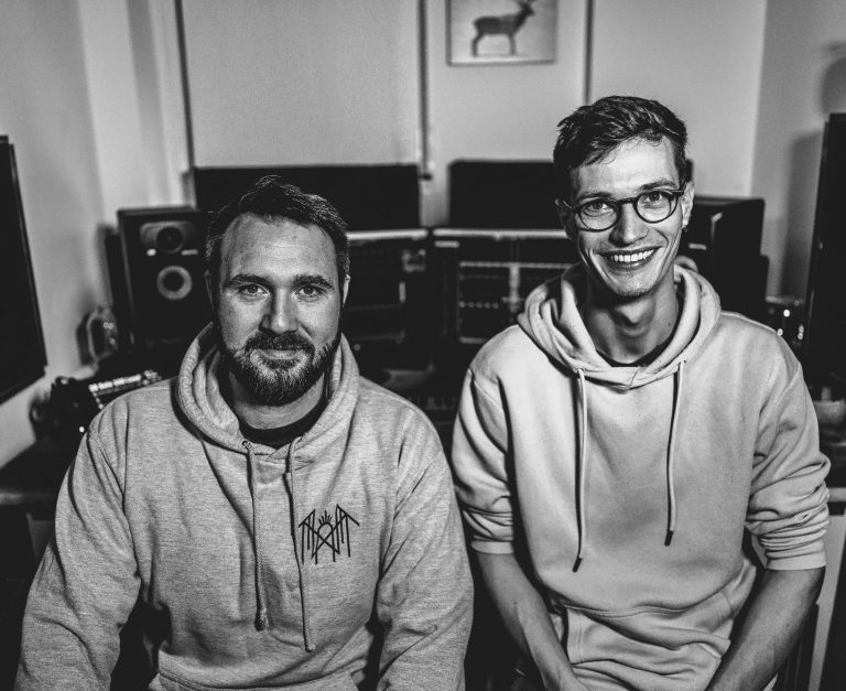 Flo und Tim in ihrem online mixing Studio Tim und Flo sitzen in ihrem Studio, umgeben von Musikgeräten und Monitoren.